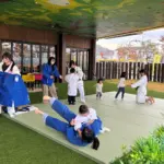 みんな集まれ!! JUDOフェスタ2025 in おかやま〜つなぐ・広げる・育む〜 IPU・環太平洋大学女子柔道部イベント 屋外でキッズと触れ合っている写真 ipu event judo festa okayama 2025 outdoor